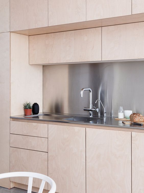 Pink kitchen cabinets ans metal backsplash
